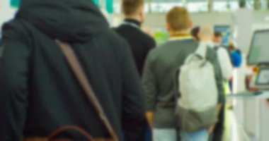 İş merkezinin içindeki büyük, parlak bir salonda birçok insan var. Bir iş temasının bulanık arkaplanı.