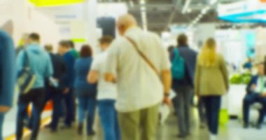 İş merkezinin içindeki büyük, parlak bir salonda birçok insan var. Bir iş temasının bulanık arkaplanı.