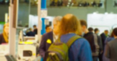 İş teması geçmişi. Büyük ve parlak bir iş merkezinde tanınmayan insanlar. Bulanık odaklı görüntü