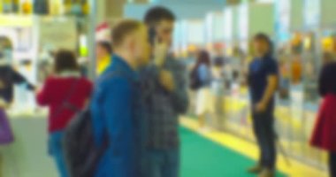 İş teması geçmişi. Büyük ve parlak bir iş merkezinde tanınmayan insanlar. Bulanık odaklı görüntü