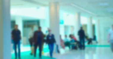 Büyük, parlak bir alışveriş merkezinde tanınmayan insanların bulanık siluetleri. Soyut iş geçmişi