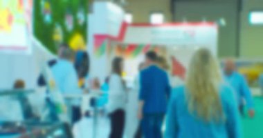 Büyük, parlak bir alışveriş merkezinde tanınmayan insanların bulanık siluetleri. Soyut iş geçmişi