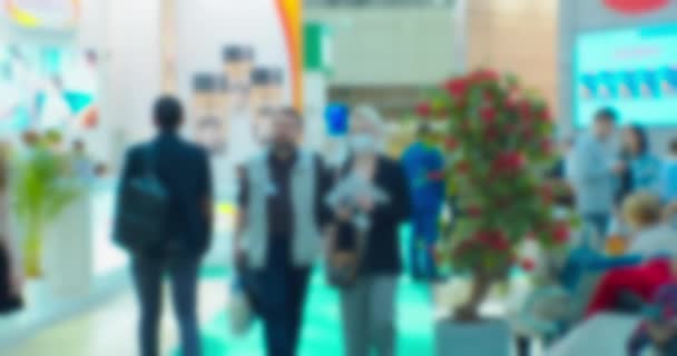 Blurred background on a business theme. Silhouettes of modern unrecognizable people inside a light mall — Stock Video