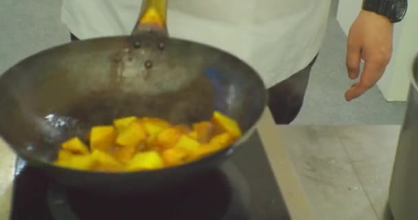 Cocina moderna.Manos masculinas de un chef irreconocible que cocina comida en una sartén de metal. — Vídeo de stock