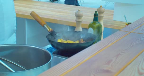 現代のキッチン。金属フライパンで食べ物を調理する認識できないシェフの男性の手クローズアップ — ストック動画