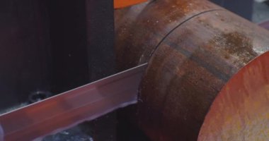 Modern endüstriyel teçhizat. Bant, soğutucu sıvısıyla ham metalleri kesen bir makine gördü. Endüstriyel testere makinesi malzeme çubuğunu yakın plan kesiyor. Teknolojik süreç yakın plan.