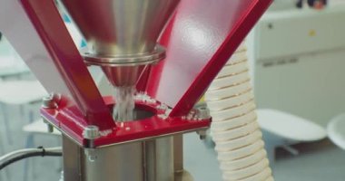 Modern üretim. Plastik işleme ve üretimi. Yuvarlak gri plastik topaklar Hopper 'dan düşer. Yakın plan. Yüzeyin derinliği