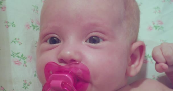 귀여운 작은 아기입니다. 깜짝 놀란 카메라를 보고 있는 아기의 모습입니다. — 비디오
