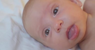 Modern bir çocuğun portresi. Yatakta yatan tatlı bir bebek. Yakından çekilmiş bir portre.