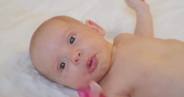 Portrait of a modern child. cute baby infant lies in bed. close-up — Stock Video