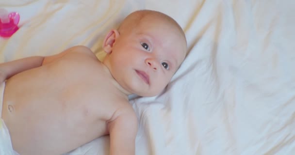 Potret seorang anak modern. bayi lucu terletak di tempat tidur. tampilan dari atas — Stok Video