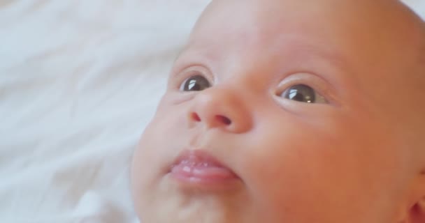 Modern bir çocuğun portresi. Yatakta yatan tatlı bir bebek. Yakından çekilmiş bir portre. — Stok video