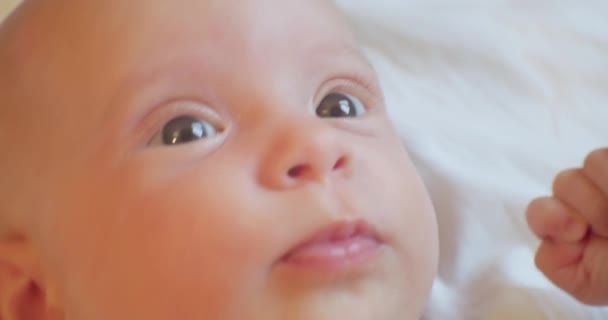 Porträtt av en rolig bebis liggande i en spjälsäng. — Stockvideo
