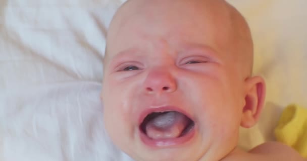 Retrato de choro bebê bonito. uma criança pequena está na cama — Vídeo de Stock