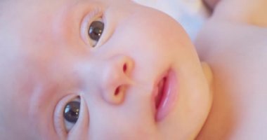 Modern, şirin, yeni doğmuş bebek portresi. Kameraya bakarken komik.