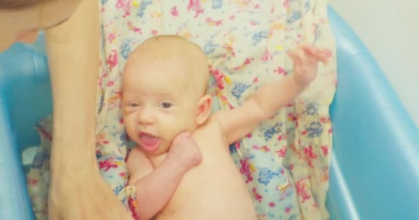 Opiekuńcze kobiety ręce umyć trochę słodkie dziecko leżące na jasnym prześcieradle w kąpieli dla dzieci — Wideo stockowe