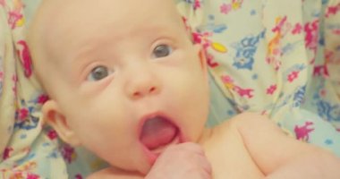 Küçük şirin komik çocuk parlak bir çarşafın üzerinde banyo yapıyor. Portre. Yakın plan.