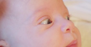 Küçük sevimli bir bebeğin şaşırmış bakışları. Bebek gözleri kapanıyor.