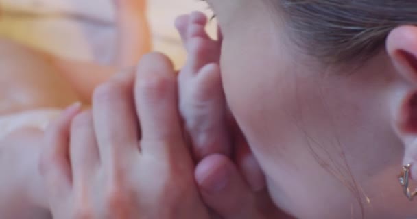 Happy childhood and motherhood.family happiness.mom gently kisses little baby feet.close-up — Vídeo de stock