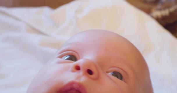 Retrato de un bebé.La cara de un niño pequeño y lindo acostado en la cama. primer plano extremo — Vídeo de stock