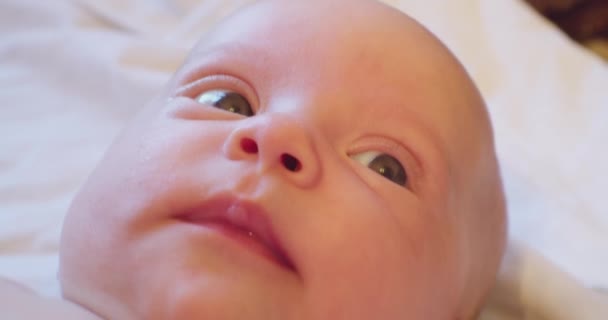 赤ん坊の肖像。ベッドに寝そべってる可愛い子の顔。極端な接近 — ストック動画