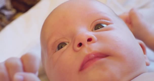 Retrato de un bebé.La cara de un niño pequeño y lindo acostado en la cama. primer plano extremo — Vídeos de Stock