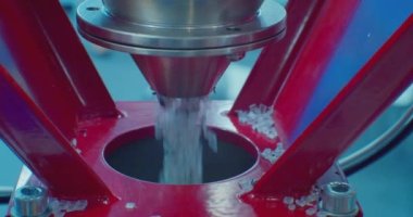 Yuvarlak gri plastik granüller zeplinden dökülüyor. Modern üretim. Plastik işleme ve üretimi. Yakın plan. Yüzeyin derinliği