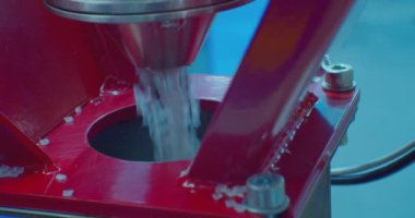 Modern teknoloji ve üretim. Plastik işleniyor. Yuvarlak gri plastik topaklar zıpzıpzıptan düşer. Yakın plan. Yüzeyin derinliği