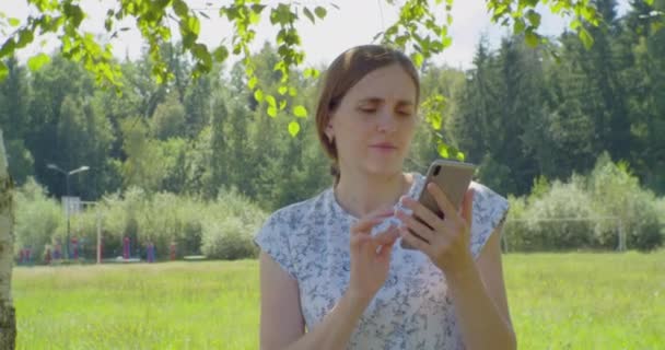 Gente moderna y tecnología. linda mujer joven con smartphone.summer retrato al aire libre — Vídeo de stock