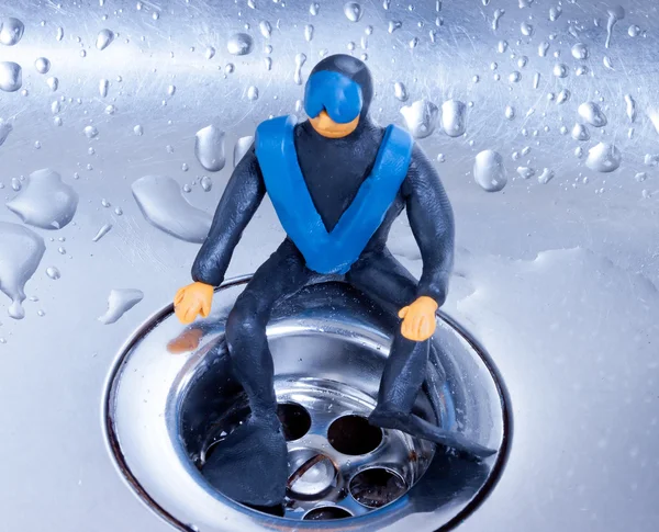 Mergulhador de plasticina pequeno sentado em uma pia de aço Fotos De Bancos De Imagens