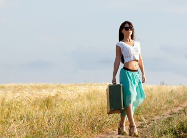 genç güzel uzun saçlı Kız bardaklarda ve elinde bir arka plan alanını kulakları ile poz bavulla.