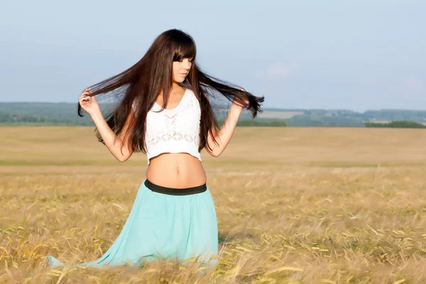 genç güzel uzun saçlı kız etek ve bluz kulakları olan bir arka plan alana poz.