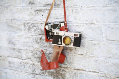 Bir tuğla duvara asılı eski fotoğraf makinesi