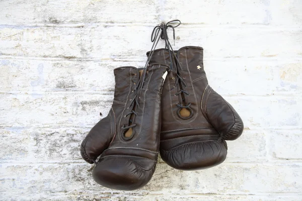 Alte Boxhandschuhe hängen an einer Ziegelwand — Stockfoto