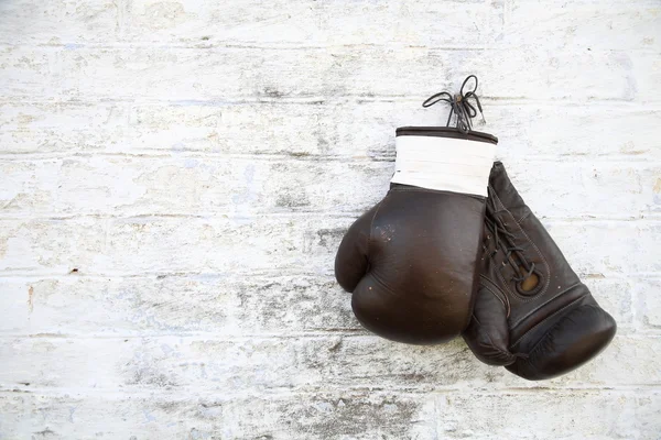 Guantes de boxeo viejos colgados en una pared de ladrillo — Foto de Stock