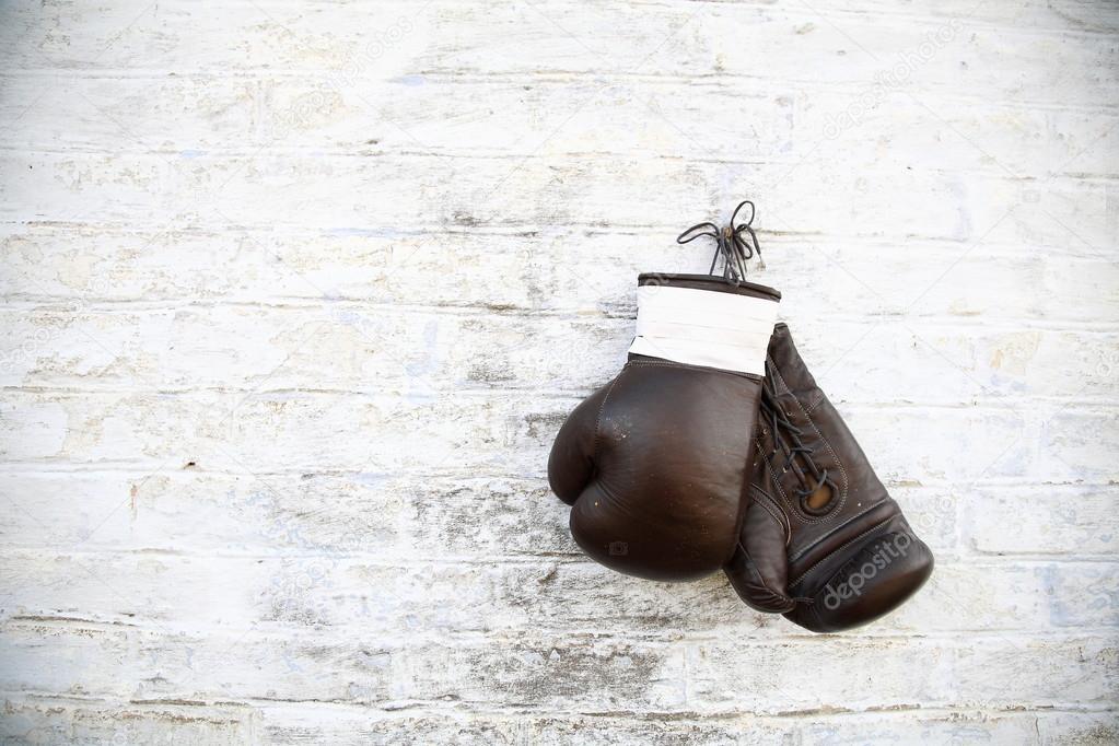 Old boxing gloves hanging on a brick wall