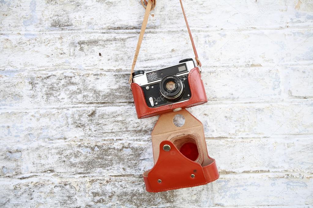 Old camera hanging on a brick wall