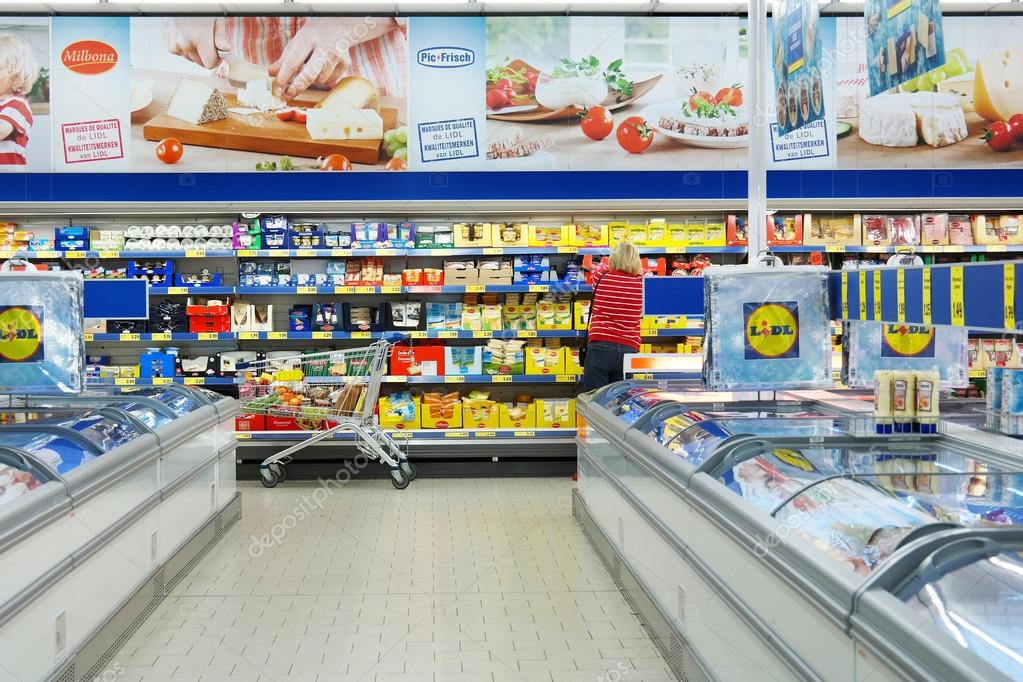 MALMEDY, BELGIUM - JULY 29, 2015: Shopper in the refrigerated fresh products aisle. Lidl is a German discount chain, 9800 stores, in 28 countries in Europe.