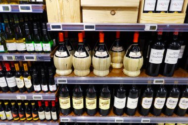 FLANDERS, BELGIUM - 2018 AĞUSTOS: Bir Carrefour Hypermarket 'teki geleneksel fiyasko sepetinde İtalyan şarabı Chianti şişeleri.