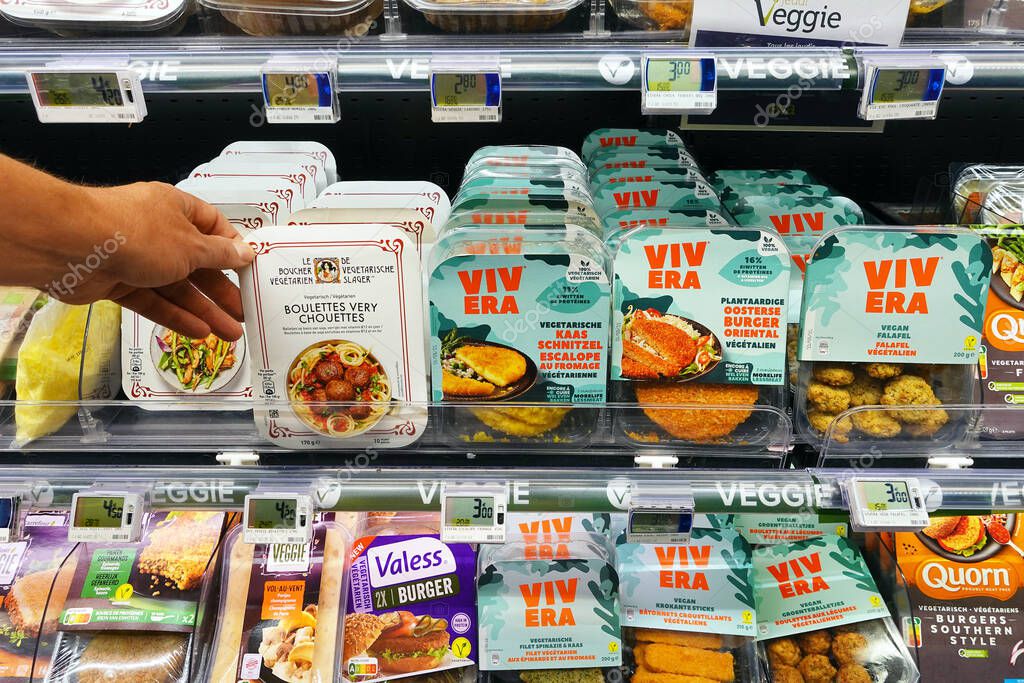 WALLONIA, BELGIUM - JULY 2021: Meat substitutes in a supermarketRefrigerated aisle with a assortment of brands plant-based meat alternatives in a Carrefour hypermarket.