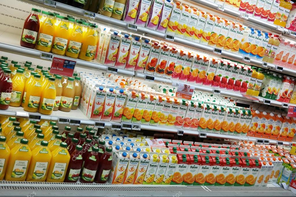 WALLONIA, BELGIUM - OCTOBER 2014: Refrigerated shelves with a variety bottles of juice at a Carrefour Hypermarket