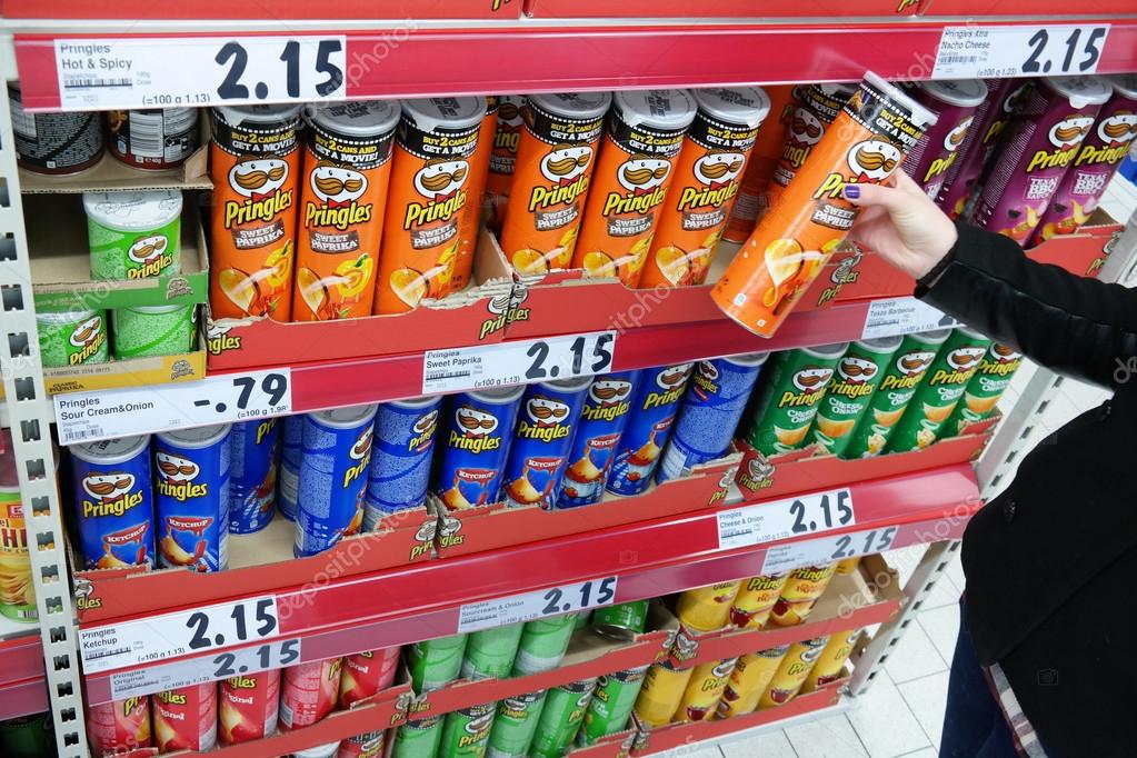 GERMANY - FEBRUARY 2015: Shelves with a variety of Pringles Chips in a Kaufland supermarket. Pringles is a brand of potato and wheat-based stackable snack chips owned by the Kellogg Company