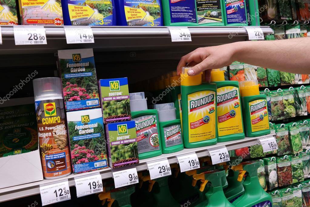 MALMEDY, BELGIUM - MAY 2015: Shelves with a variety of Herbicides in a Carrefour Hypermarket. Roundup is a brand-name of an herbicide made by Monsanto.