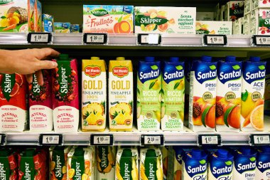 Alışveriş yapan kişi, marketten Skipper marka kırmızı meyve suyu kartonunu seçiyor. Santal, Lactalis International 'ın bir markası.