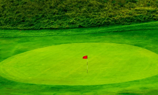 Campo de golfe verde e sua bandeira — Fotografia de Stock