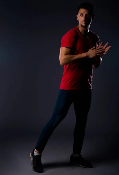 スタイリッシュなブルージーンズ 赤いTシャツ スニーカーを身に着けているクールなハンサムな男 — ストック写真
