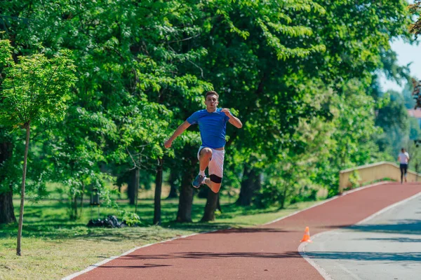 Kaukasische Jonge Mannelijke Loper Sportkleding Springen Het Park — Stockfoto