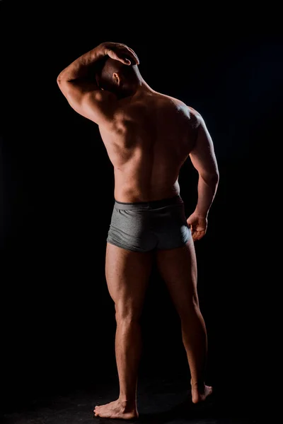 黒の背景に筋肉男の胴 ボディービル運動選手の肖像画 — ストック写真