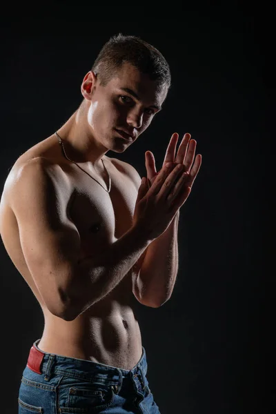 Portrait of a strong healthy handsome athletic man posing as a fitness model on dark background