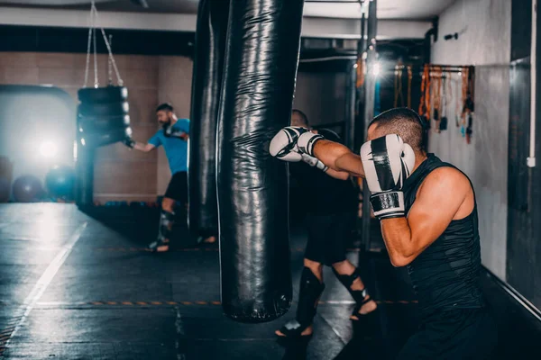 Muskulöser Kämpfer Der Ein Paar Schläge Mit Boxsack Boxhandschuhen Übt — Stockfoto